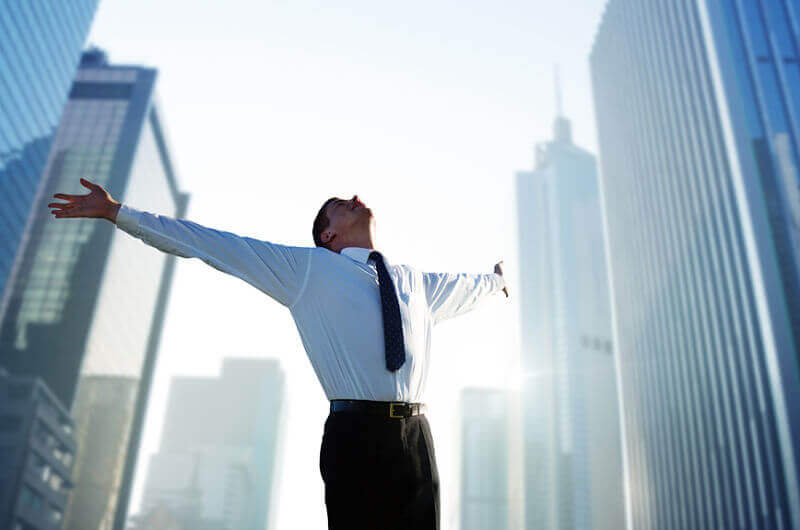 Happy young businessman and big city