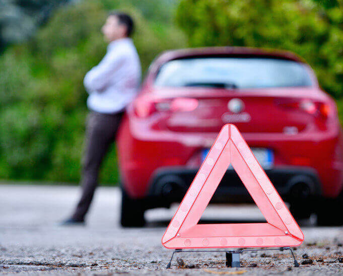 Red warning triangle with a broken down car