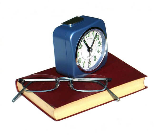 Relógio, óculos, livros